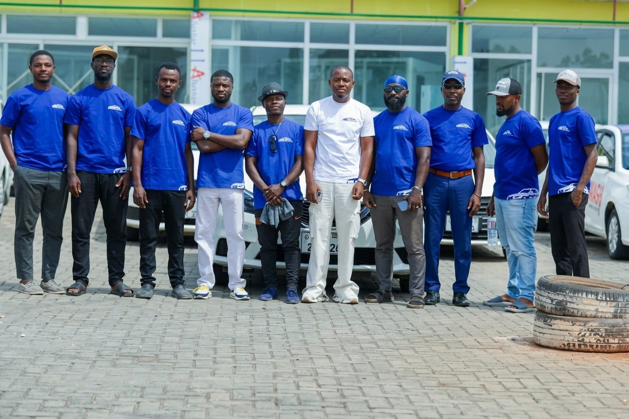 The Axtro Capital Technologies team in branded shirts in front of the fleet