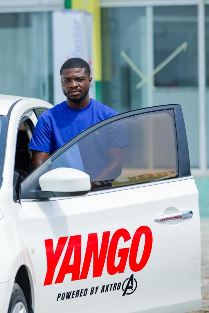 Axtro EV driver partner beside a branded Yango car door