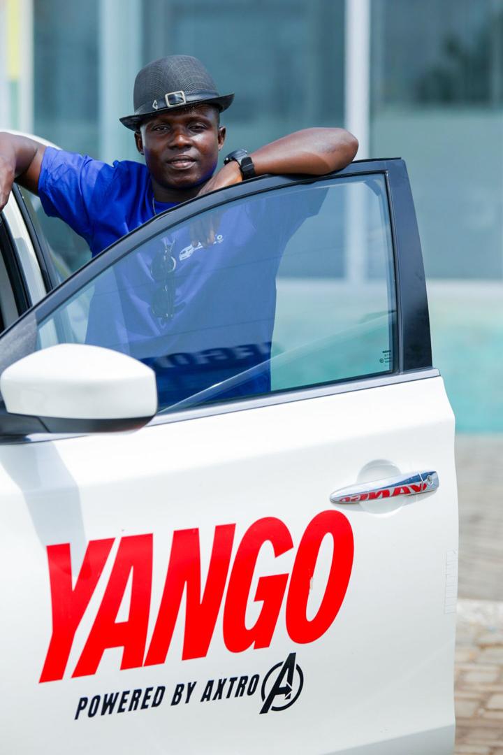 Axtro commercial EV driver standing with a branded electric sedan