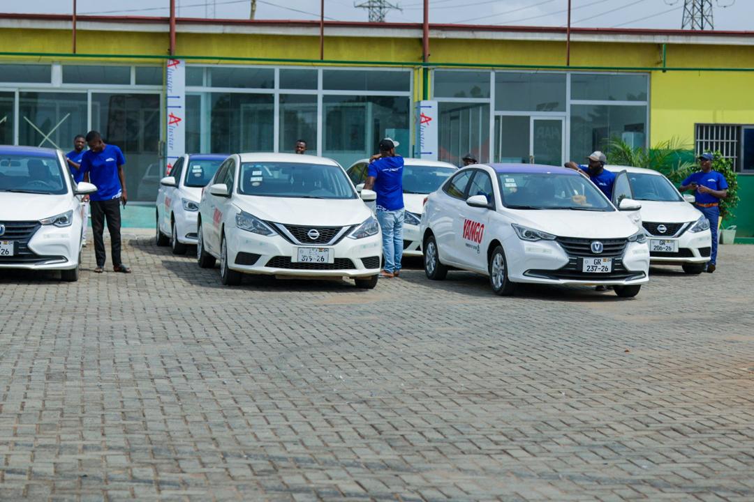 Certified drivers with white electric sedans ready for commercial routes